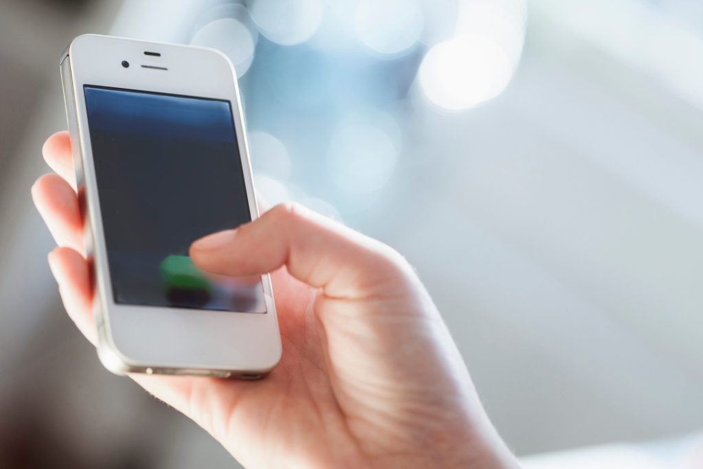 Young woman using smart phone, close up